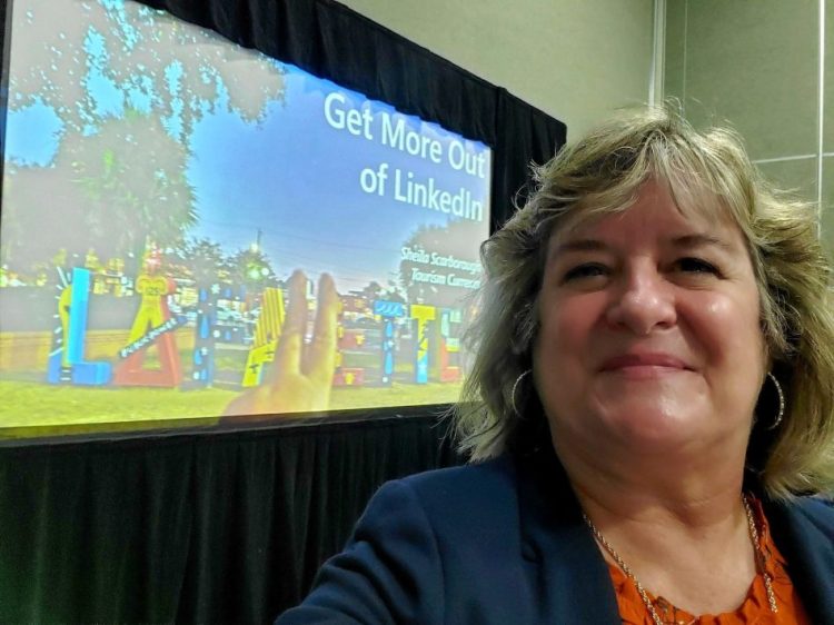 Sheila Scarborough Tourism Currents at TBEX Lafayette in front of slide about LinkedIn
